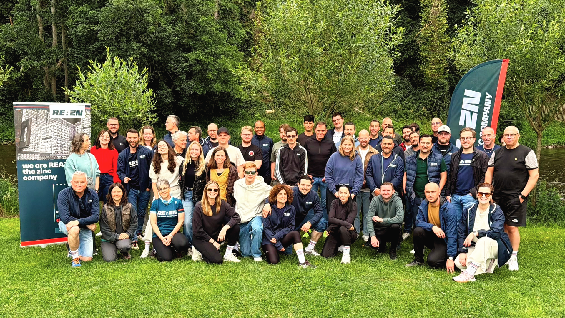 Large group of REAZN employees gathered for a team event outdoors, celebrating company culture and camaraderie
