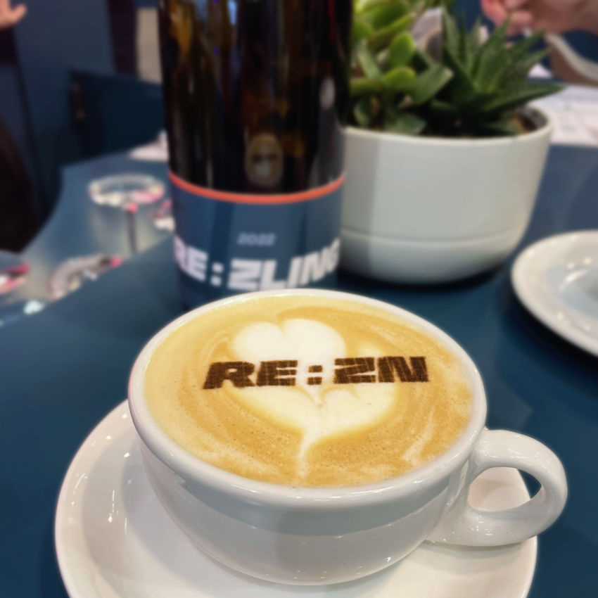 Cappuccino with latte art featuring REAZN logo, showcasing REAZN's brand identity and worklife culture