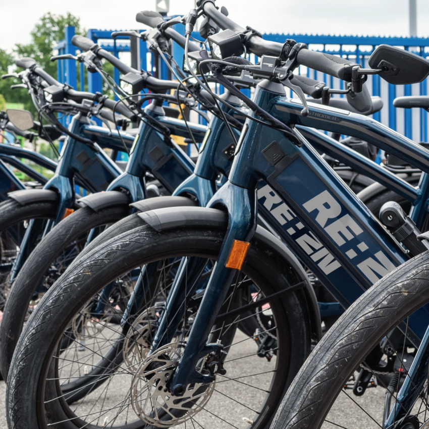 Row of REAZN branded electric bicycles, promoting sustainable commuting at REAZN