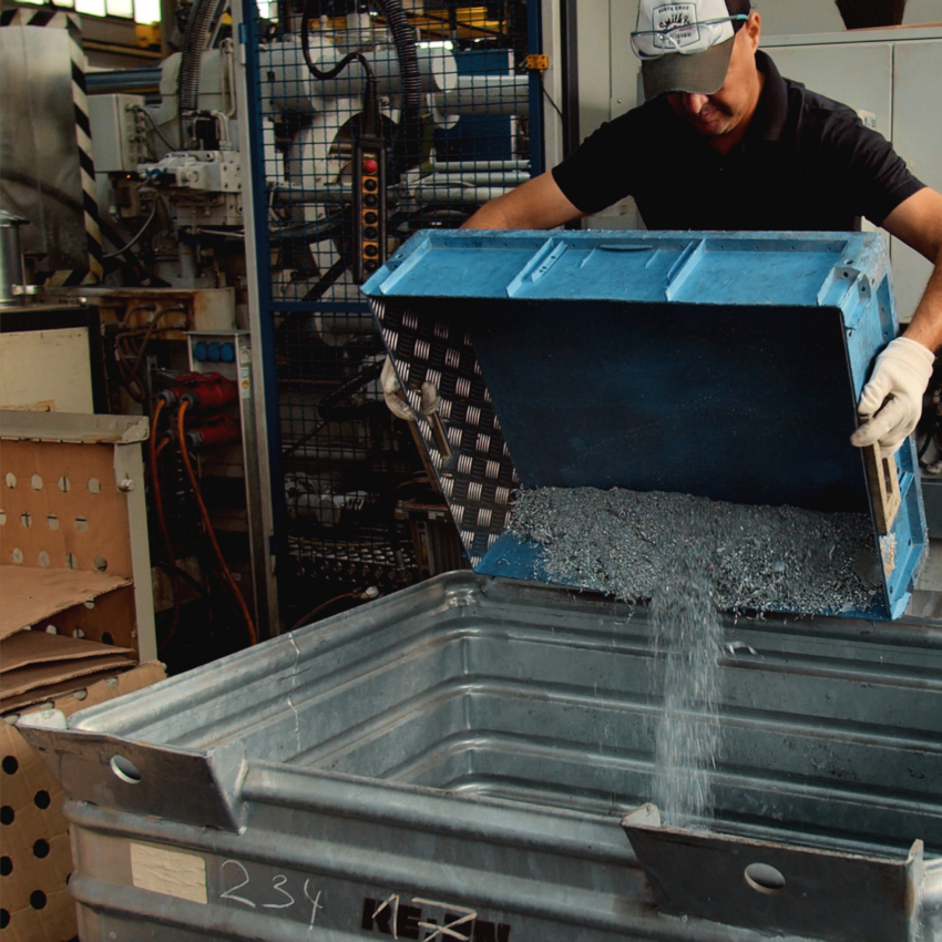 REAZN employee loading zinc scrap material into a collection box during the recycling process