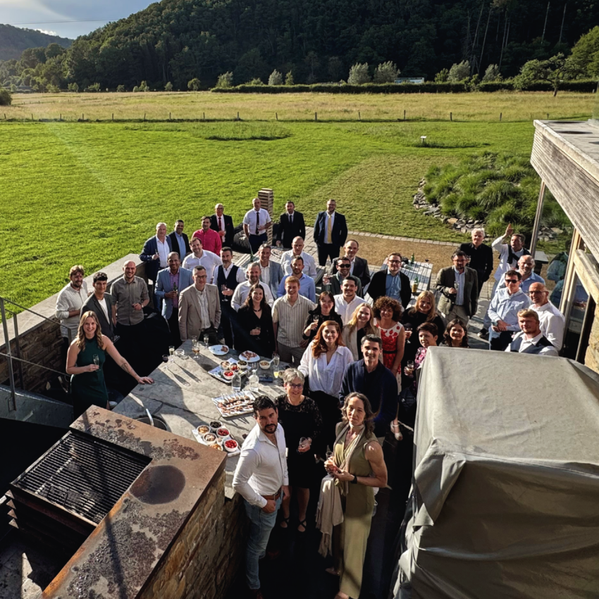 Large group of REAZN employees gathered for a team event outdoors, celebrating company culture and camaraderie