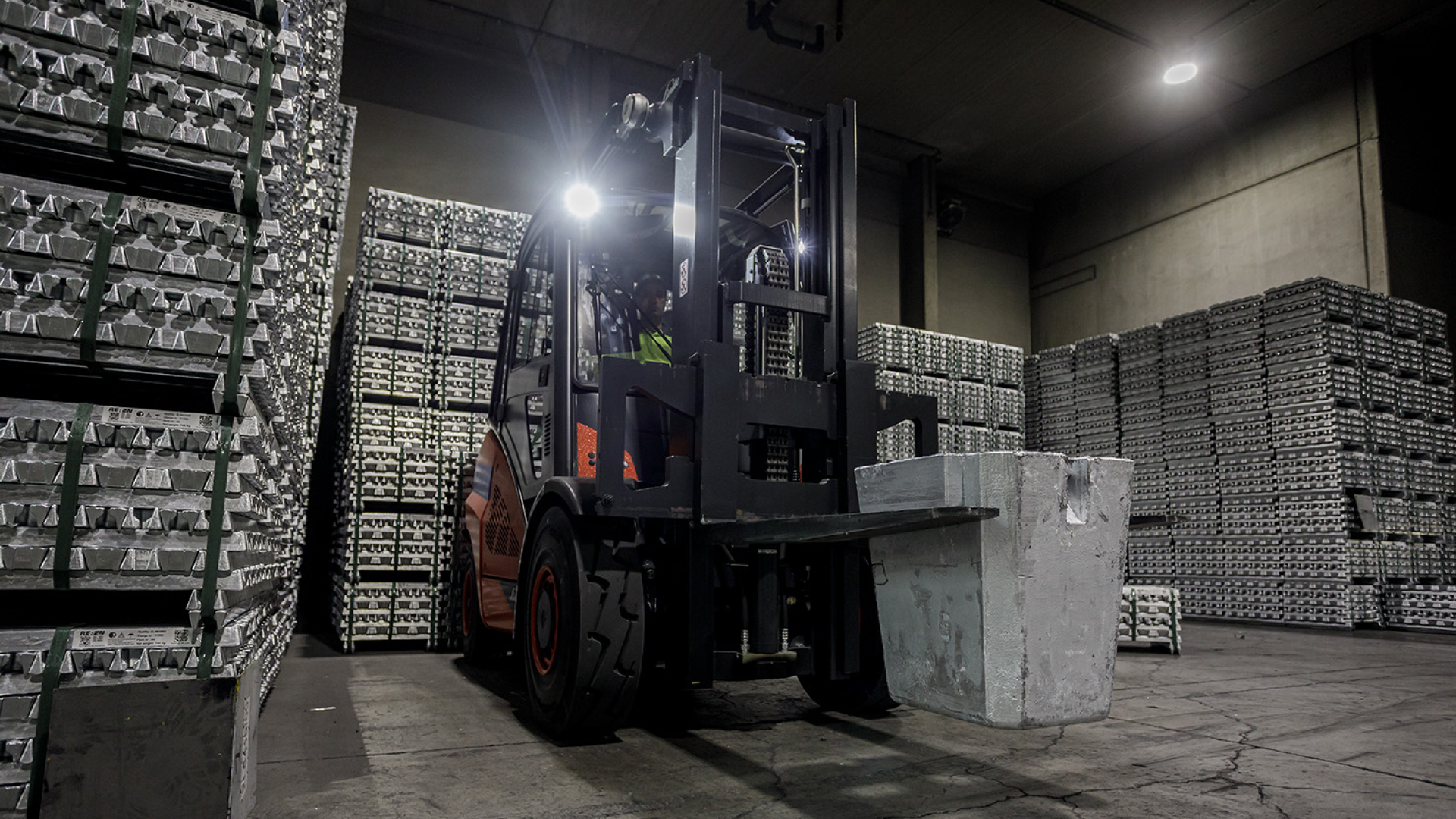Forklift operator transporting recycled zinc product pallets in a REAZN warehouse facility