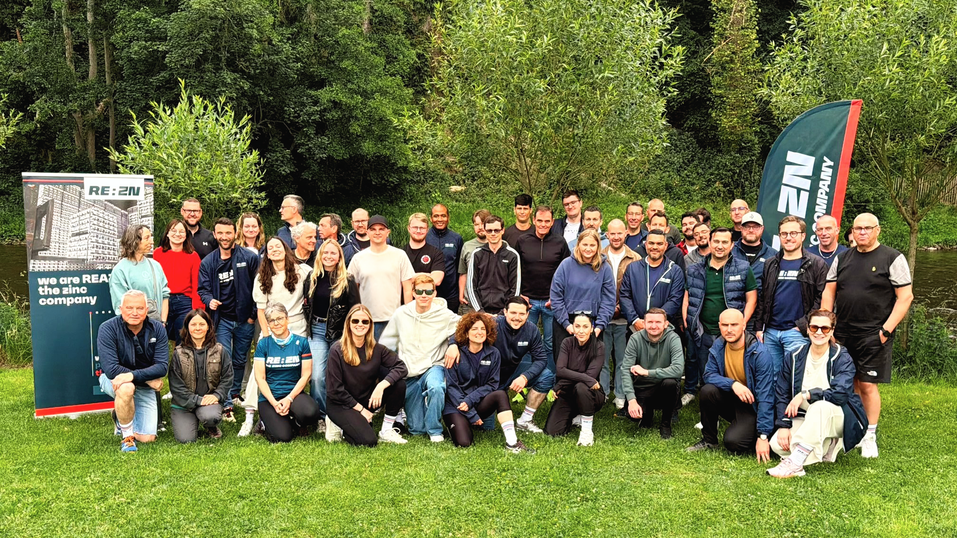 Large group of REAZN employees gathered for a team event outdoors, celebrating company culture and camaraderie